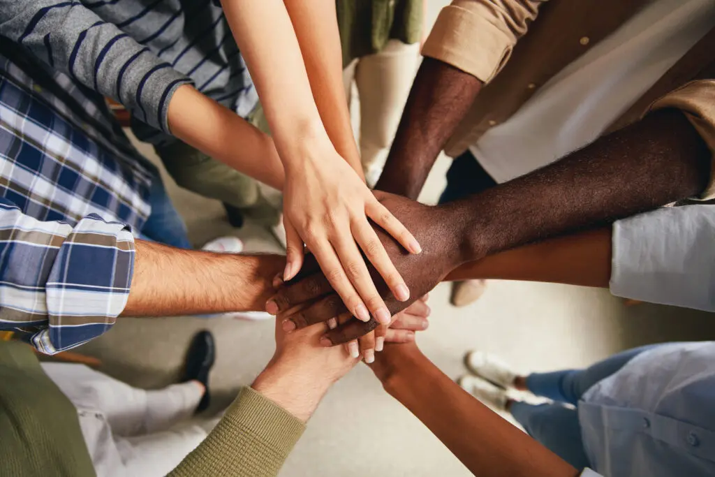 Cropped photo of multiracial people hands put on top of each other symbolizing unity